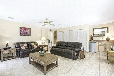 A living room with a black couch and a wooden coffee table.