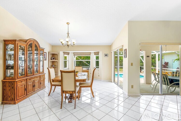 A dining room with a wooden table and chairs.