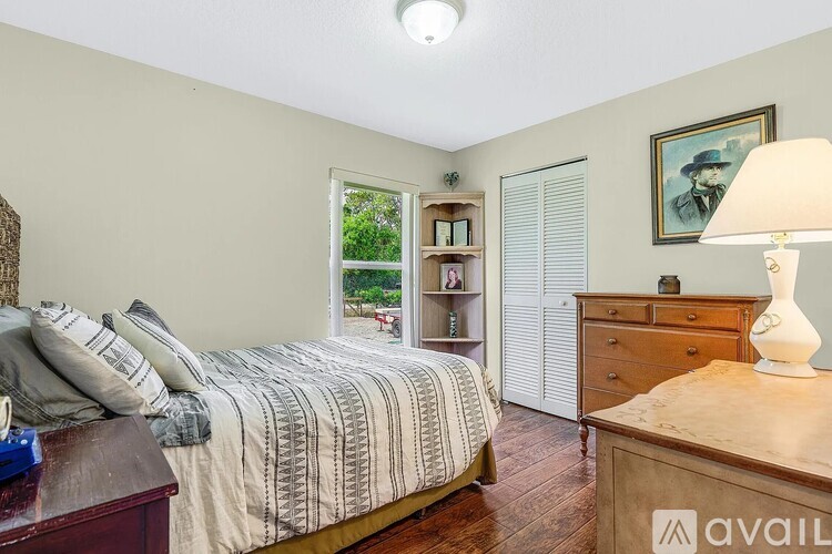 A bedroom with a bed, nightstand, and a lamp.
