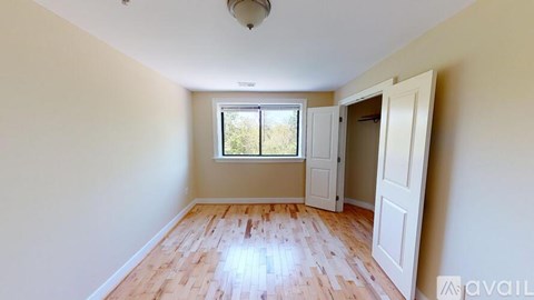 A room with a window and a wooden floor.