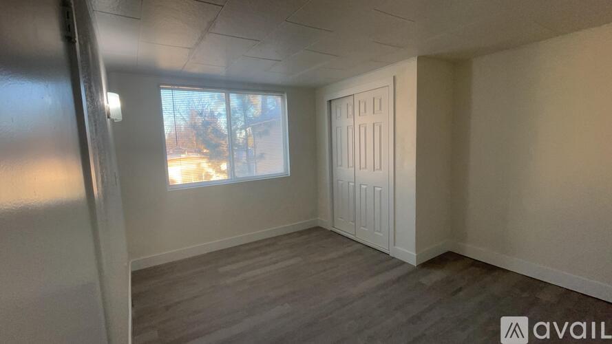 A room with a window and a door is available for rent.
