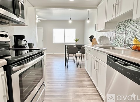 A kitchen with white cabinets and a wooden floor.