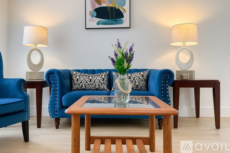A blue sofa with a wooden coffee table in front of it.