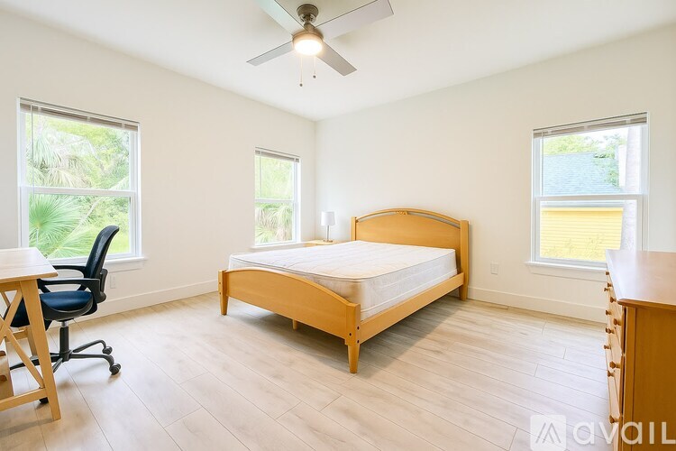 A bedroom with a bed, desk, and chair.