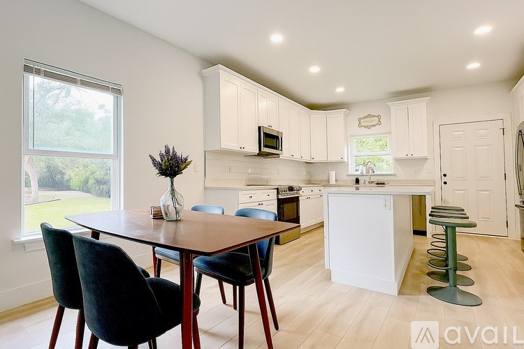 A kitchen with a table and chairs in front of it.