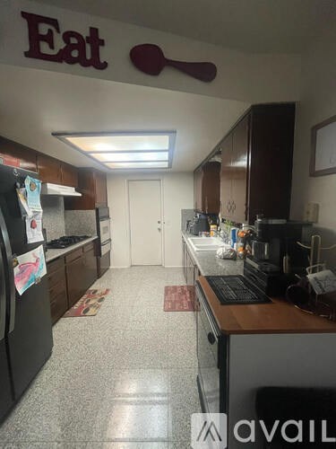 A kitchen with a refrigerator and a counter.