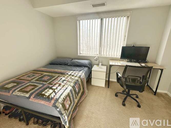 A bedroom with a bed, desk, and chair.