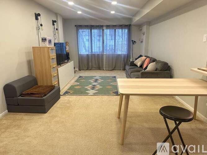 A living room with a grey couch, a wooden table, and a television.