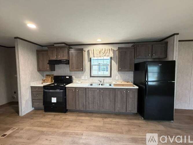 A kitchen with black appliances and wooden cabinets.