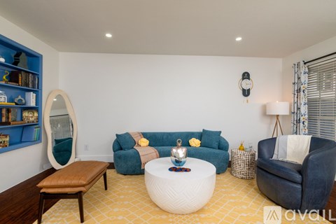A living room with a white coffee table and a blue couch.