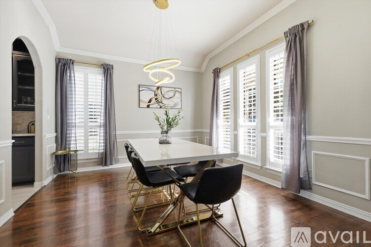 A dining room with a table and chairs.