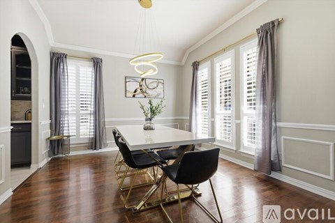 A dining room with a table and chairs.