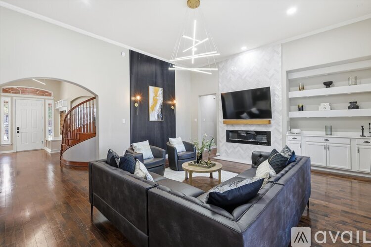 A living room with a grey couch and a wooden floor.