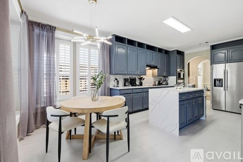 A modern kitchen with a round table and chairs in the center.