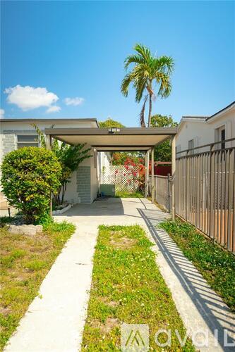 A pathway leads to a covered walkway between two buildings.