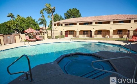 A pool with a ladder in front of a building with a balcony.