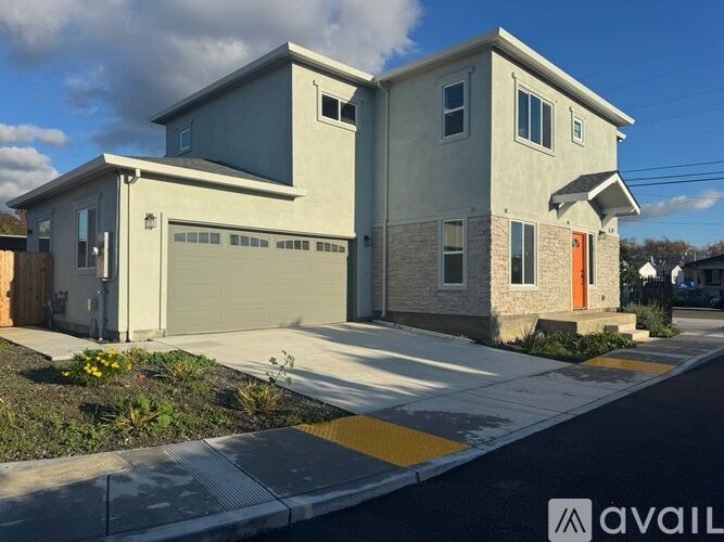 A modern two-story house with a garage and a red door.