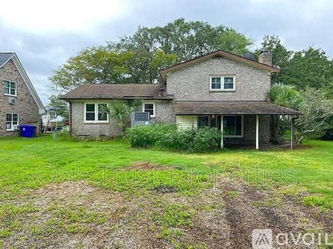 A house with a grey roof and a green lawn in front.