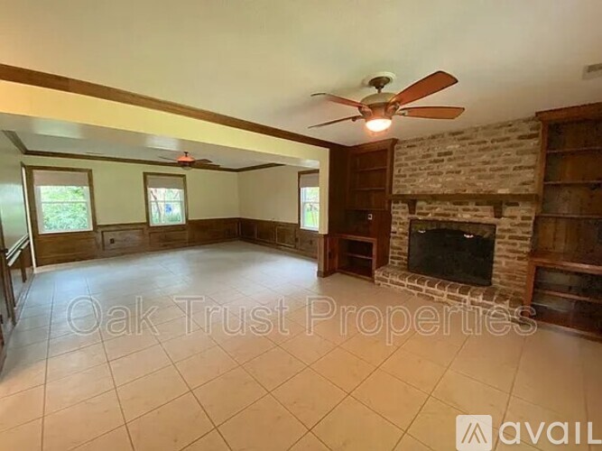 A living room with a fireplace and a ceiling fan.