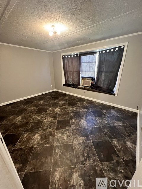 A room with a tiled floor and a window with curtains.