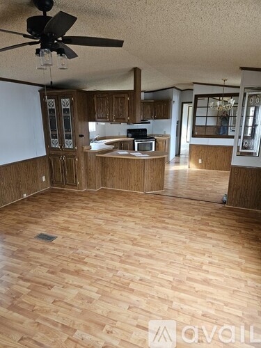 A room with wooden flooring and a ceiling fan.
