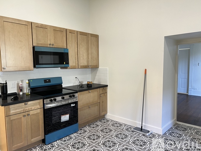 A kitchen with wooden cabinets and a black and white floor.