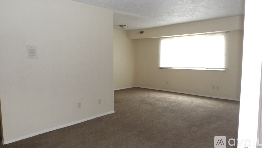 A room with a window and carpeted floor.