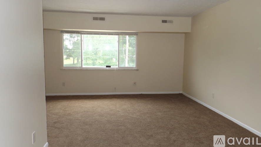 A room with a carpeted floor and a window.
