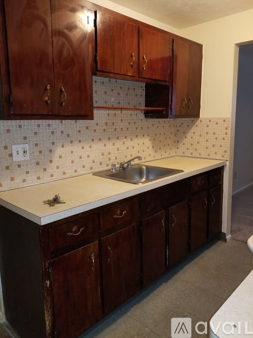 A kitchen with brown cabinets and a white counter top.