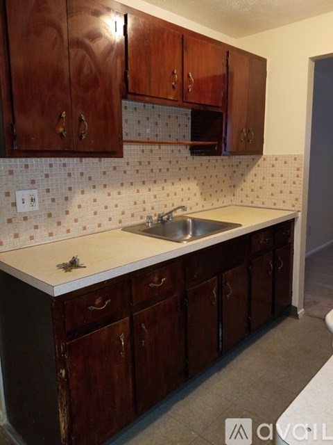 A kitchen with brown cabinets and a white counter top.