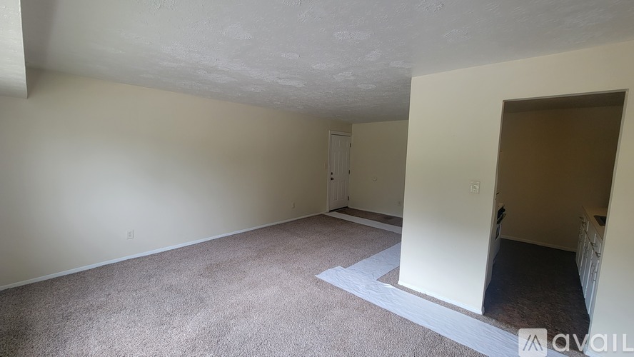 A room with a carpeted floor and a doorway leading to another room.