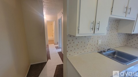 A kitchen with white cabinets and a sink.