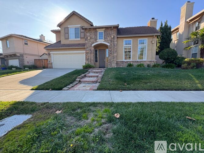 A house with a stone facade and a garage door is for sale.