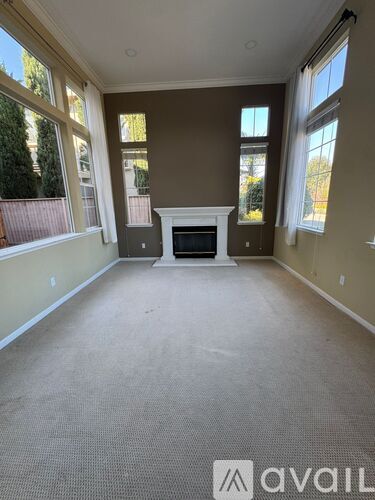 A living room with a fireplace and large windows.