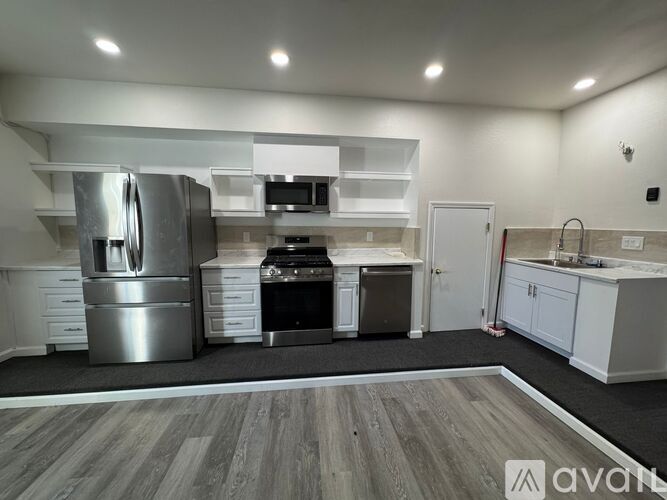 A modern kitchen with stainless steel appliances and white cabinets.