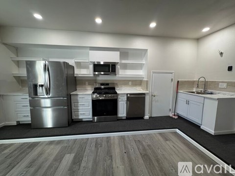 A modern kitchen with stainless steel appliances and white cabinets.