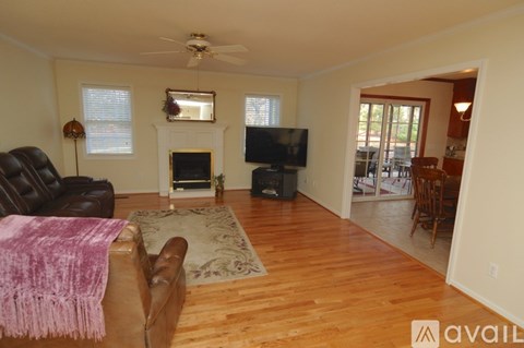 A living room with a brown leather couch and a television.