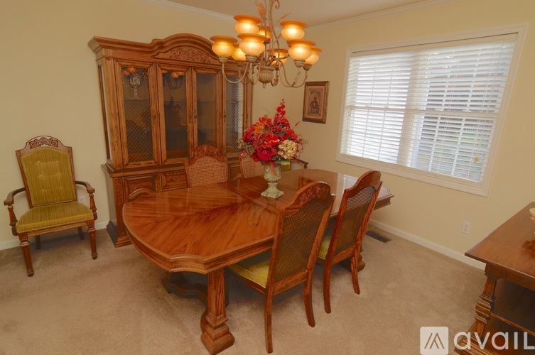 A dining room with a wooden table and chairs.