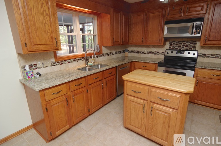 A kitchen with wooden cabinets and a granite countertop.
