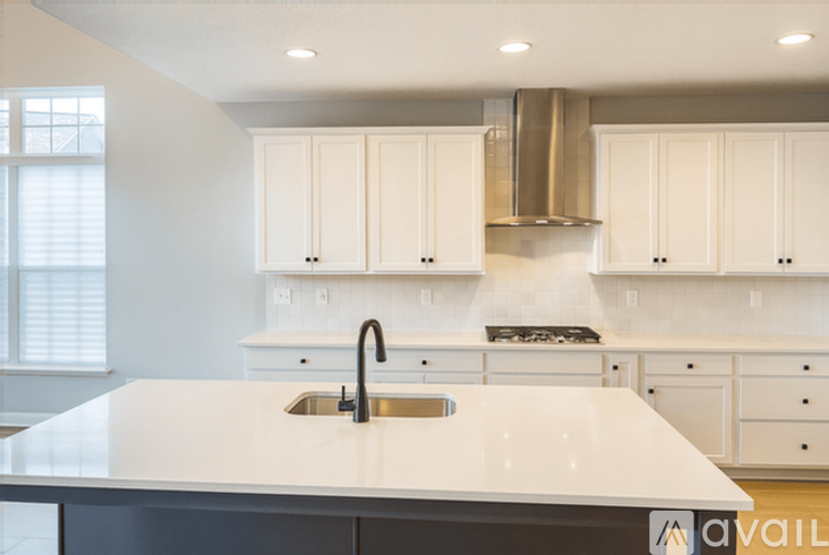 A modern kitchen with white cabinets and a large island.