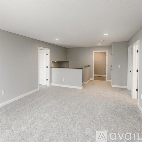 A spacious living room with a carpeted floor and a bar area.