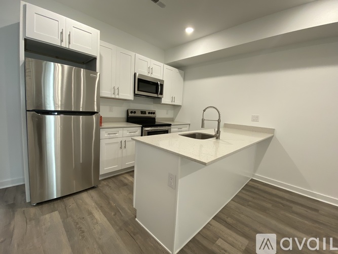 A modern kitchen with a stainless steel refrigerator and white cabinets.
