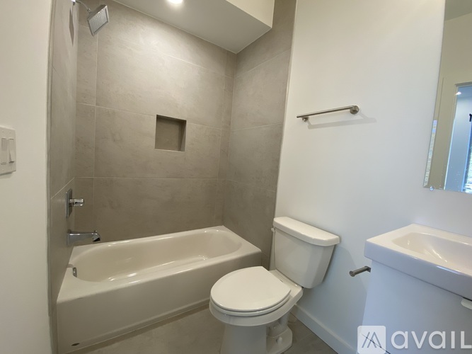 A bathroom with a white toilet, a bathtub, and a sink.