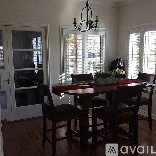 A dining room with a table and chairs.