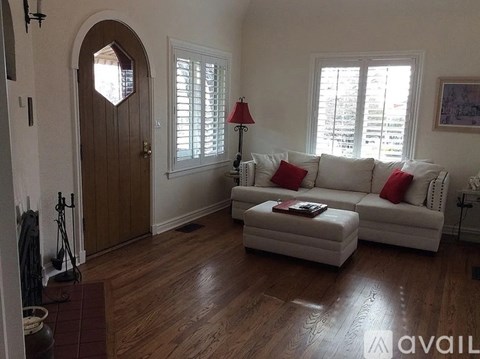 A living room with a white couch and a wooden floor.