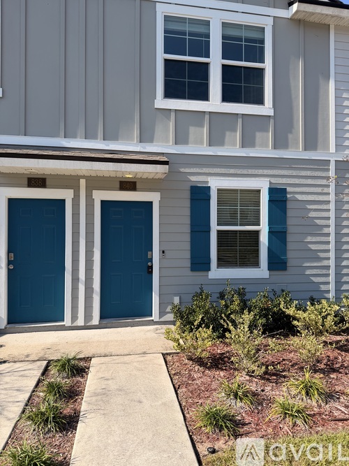 A house with a white and blue exterior and a white window with blue shutters.
