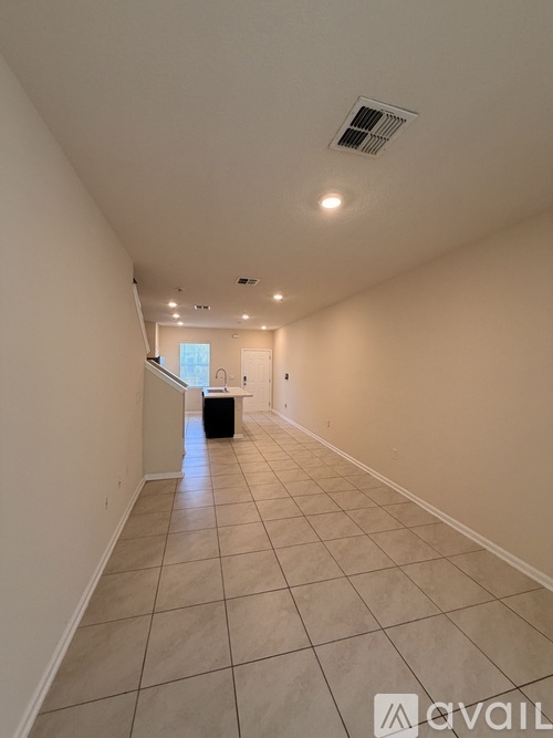 A long hallway with tiled floors and white walls.