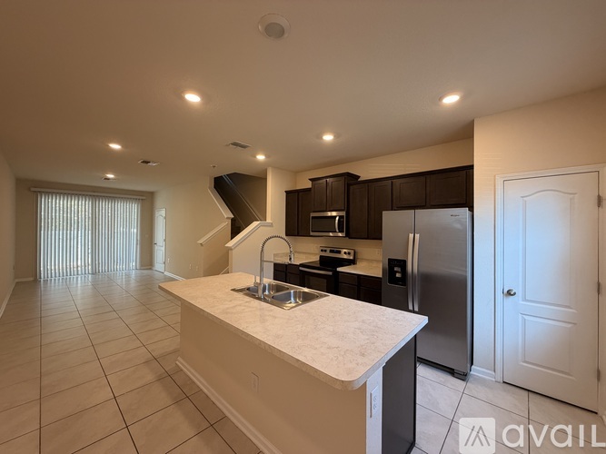 A kitchen with a marble countertop and stainless steel appliances.