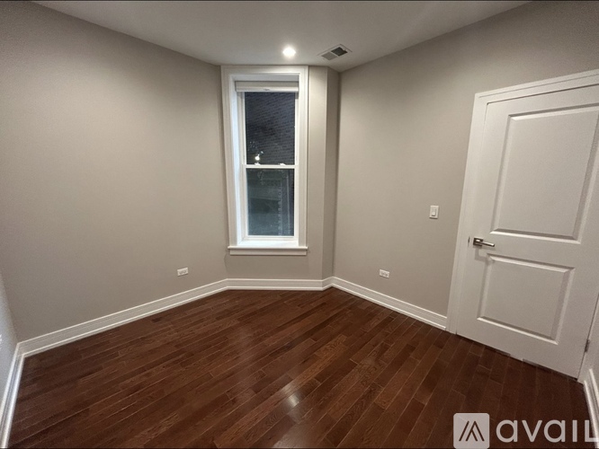A room with a wooden floor and a white door.