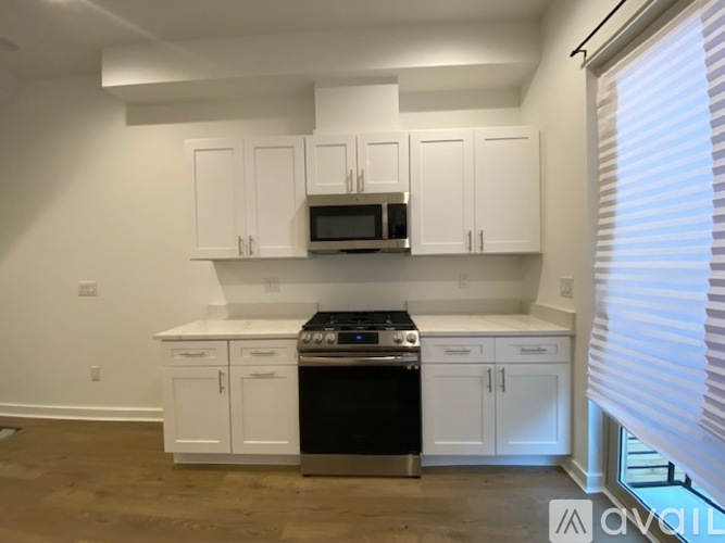 A kitchen with white cabinets and a black stove top oven.